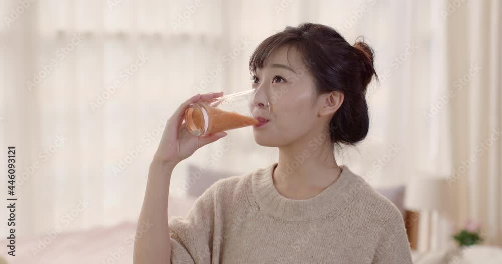 Young Chinese woman drinking juice at home,4K
