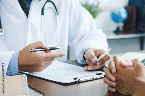 Doctor giving a prescription to the patient. Doctor hand holds silver pen filling patient history list at clipboard pad. Physical, exam, disease prevention, ward round,