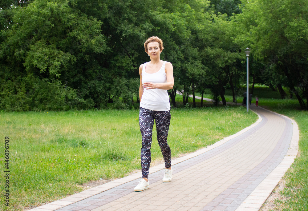 Beautiful young woman goes in for sports in the park in nature. The woman is engaged in fitness in sportswear. Beautiful young woman goes in for sports in the park in nature. The woman is engaged in fitness in sportswear.