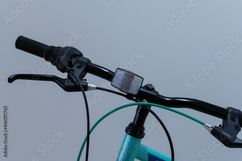 White reflector on the front handlebar of a kids bicycle