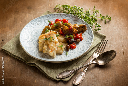 cooked cod with artichoke tomatoes olives capers and herbes
