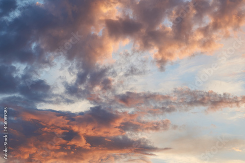 Beautiful evening blue sky at sunset with flaming bright light clouds. A warm summer evening at sunset. Bright sunset.