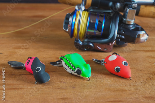 Soft plastic frog lure with fiishing spinning  ,Fishing bait on wooden background.