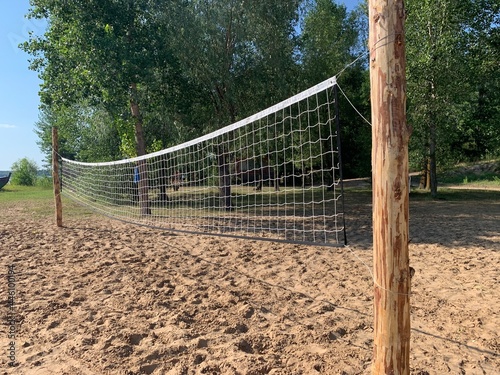sport net on the beach; A beach volleyball net on a sunny day, on an empty beach forest 
