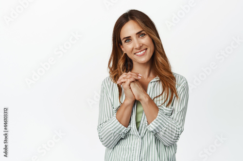 Tender and beautiful middle aged woman, looking at smth adorable, expres sympathy, smiling pleased, feel touched and grateful, standing against white background