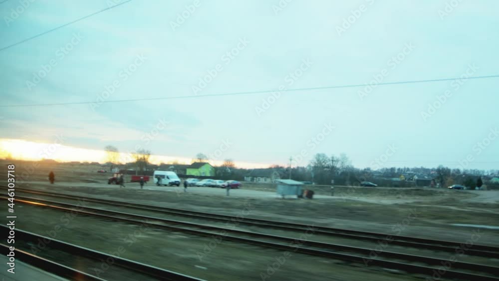View from the train window while driving on the railway and a sunny sunset in the sky, background. Transportation View from the train window while driving on the railway and a sunny sunset in the sky, background. Transportation
