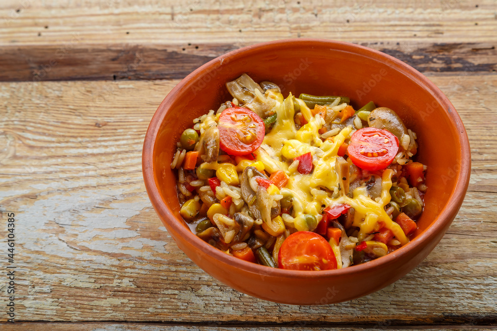 Risotto with mushrooms and cheese in a clay plate on a wooden background. Risotto with mushrooms and cheese in a clay plate on a wooden background.