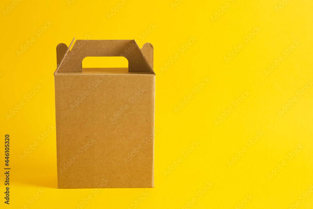 cardboard box on a yellow background, gift box without logo, blank packaging for your design cardboard box on a yellow background, gift box without logo, blank packaging for your design