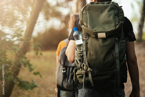 Male and female couple going outdoors backpacking, captured from behind