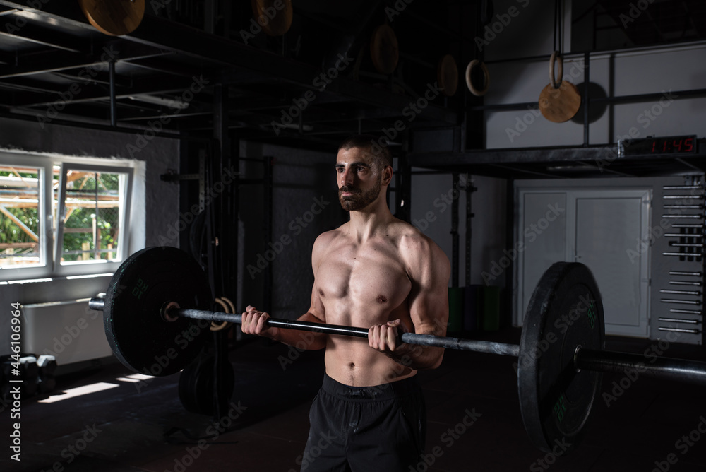Young active sweaty muscular fit strong man with big muscles doing biceps curly with heavy barbell weight in the gym as hardcore workout cross training real people exercise Young active sweaty muscular fit strong man with big muscles doing biceps curly with heavy barbell weight in the gym as hardcore workout cross training real people exercise