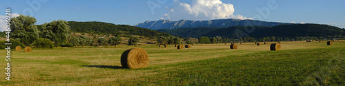 Rural fields with hay bales with mountains on the background at Rocca di Mezzo upland , Abruzzo , Italy