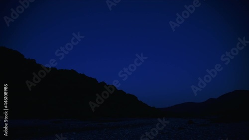 Wallpaper Mural Early morning on the bank of a mountain river filmed in time laps. The stars move across the dark blue sky. Dawn breaks out. The stars go out and morning comes. Torontodigital.ca