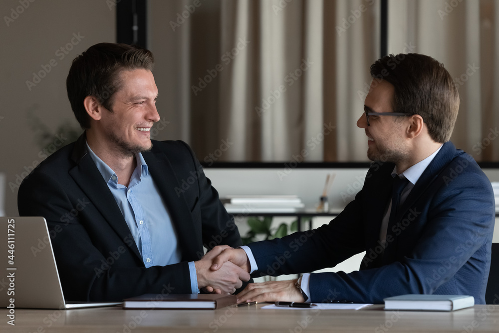 Two businessmen shaking hands at workplace. Client thanking lawyer, expert, advisor for consultation. Employer hiring candidate after job interview. Business partners closing deal with handshake Two businessmen shaking hands at workplace. Client thanking lawyer, expert, advisor for consultation. Employer hiring candidate after job interview. Business partners closing deal with handshake