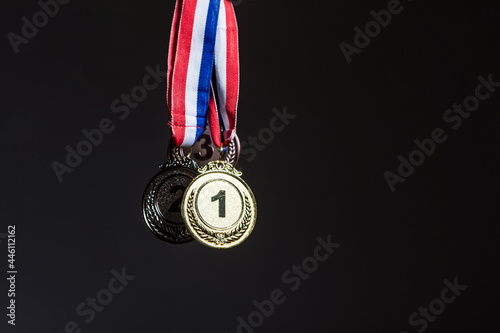 Three gold, silver and bronze medals hanging on a dark background. Sports and victory concept.