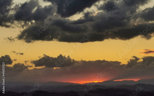 Tramonto sulle montagne e le valli dell’Appennino con grandi nuvole colorate cariche di pioggia © GjGj