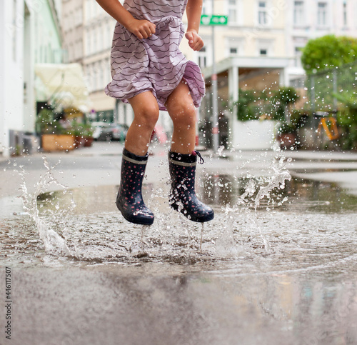 Girl playing in the puddle on summer day. Seasonal water leisure activity for children outdoors.
Mädchen, das am Sommertag in der Pfütze spielt. Saisonale Wasserfreizeitaktivität für Kinder im Freien.