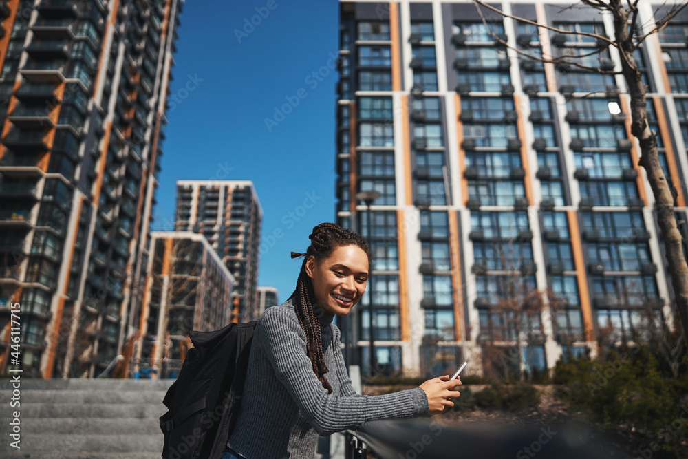 Jolly tourist with a backpack and a smartphone looking ahead Jolly tourist with a backpack and a smartphone looking ahead