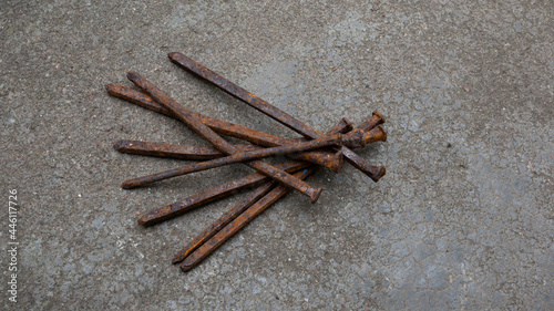 Fototapeta Naklejka Na Ścianę i Meble -  A pile of rusty used nails on a concrete background.