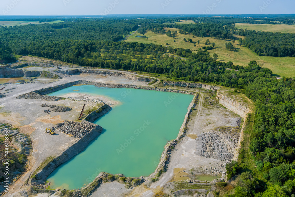 Aerial view in Open pit stone extraction in the canyon with deep green lake