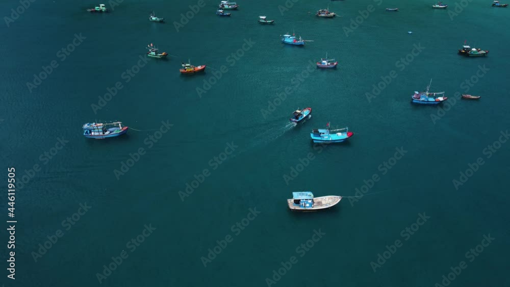 Aerial view. Beautiful shot of the colorful fishing boat going to the port. Turquoise water of the sea in a paradise of a tropical island the stunning nature somewhere in southeast Asia. Aerial view. Beautiful shot of the colorful fishing boat going to the port. Turquoise water of the sea in a paradise of a tropical island the stunning nature somewhere in southeast Asia.