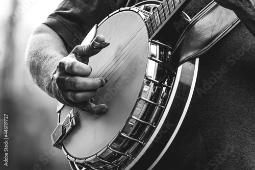 Foto mature, older man, male playing five string banjo outside in monochrome black an