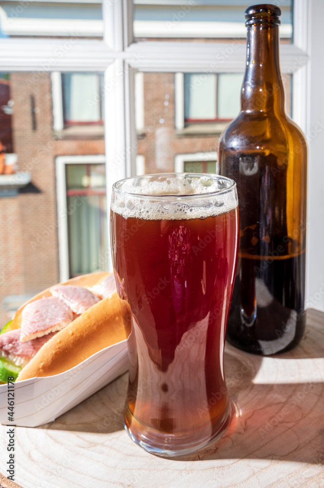 Drinking dark beer with smoked eel fish sandwich with view on street in old Zierikzee town, Zeeland, Netherland Drinking dark beer with smoked eel fish sandwich with view on street in old Zierikzee town, Zeeland, Netherland