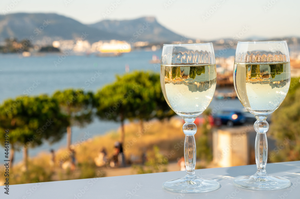 Fototapeta premium Summer on French Riviera, drinking cold white wine from Cotes de Provence on outdoor terrase with view on harbour of Toulon, Var, France