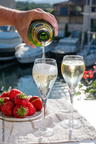 Summer party, pouring of French champagne sparkling wine in glasses in yacht harbour of Port Grimaud near Saint-Tropez, French Riviera vacation, France