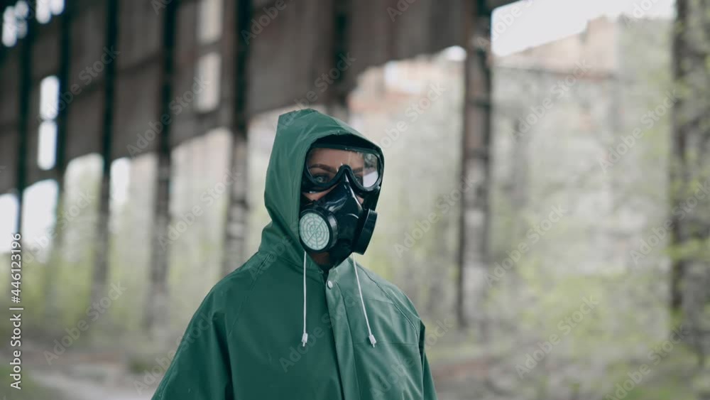 Person in chemical protective suit standing in distracted place. Survivor in abandoned place with piles of garbage from ruined buildings. Apocalypse concept Person in chemical protective suit standing in distracted place. Survivor in abandoned place with piles of garbage from ruined buildings. Apocalypse concept