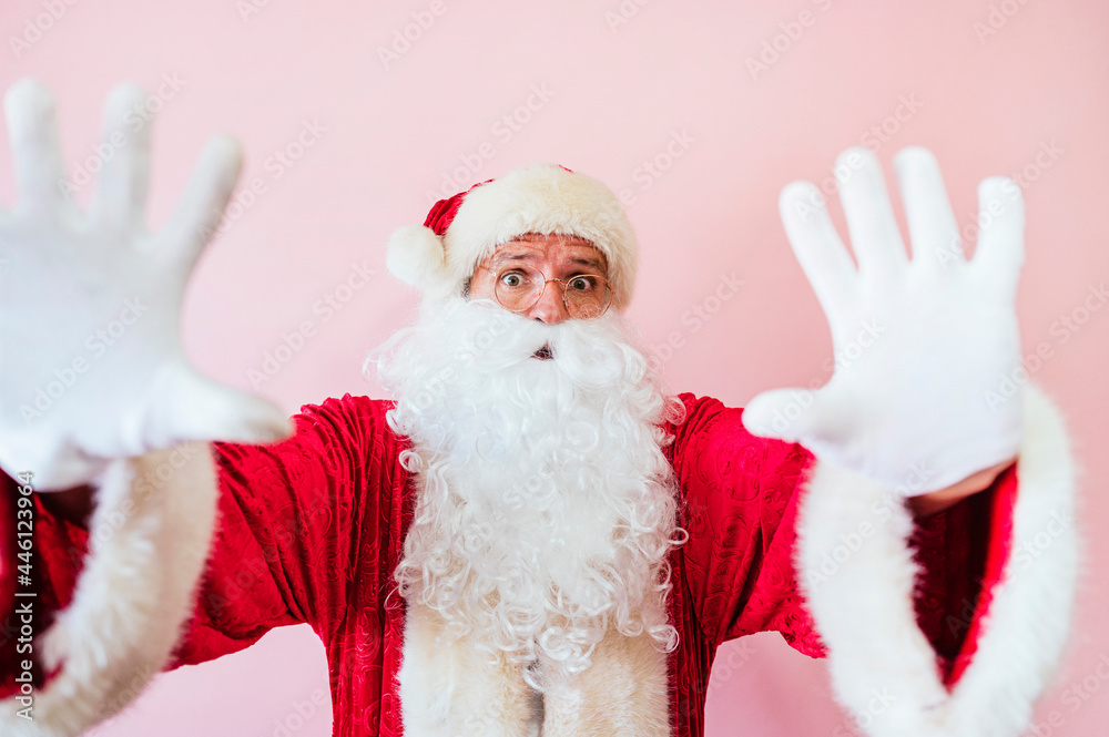 Man dressed as Santa Claus looking at camera with palms in stop sign Man dressed as Santa Claus looking at camera with palms in stop sign