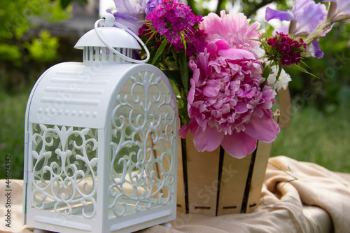 here are white lamp,fresh flowers on the table.