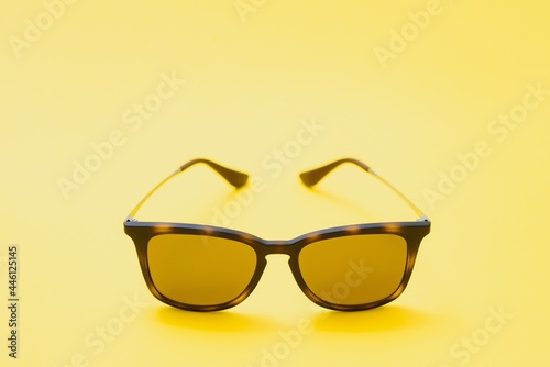 Brown glasses on yellow background