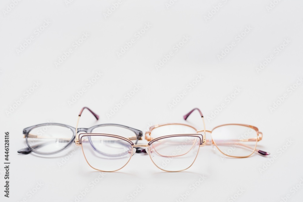Fototapeta premium Stylish eyeglasses over background. Optical store, glasses selection, eye test, vision examination at optician, fashion accessories concept. Top view, flat lay