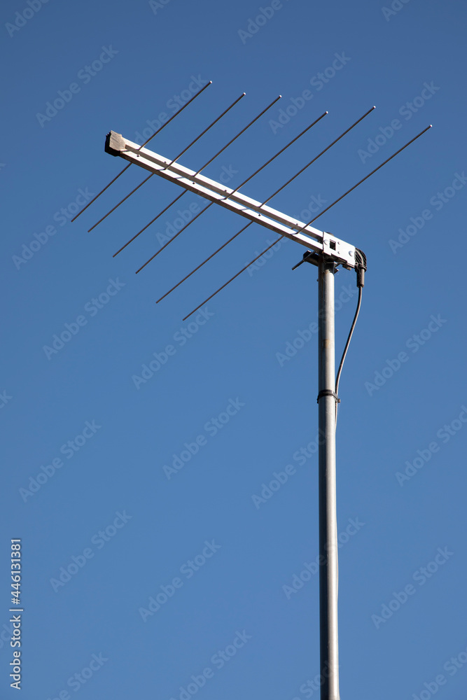 A television antenna against a blue sky background A television antenna against a blue sky background