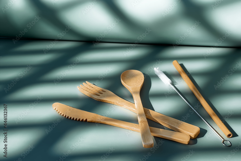 Eco friendly bamboo cutlery set on light green pastel background with geometric shadows. Zero waste, plastic-free lifestyle concept. Eco friendly bamboo cutlery set on light green pastel background with geometric shadows. Zero waste, plastic-free lifestyle concept.