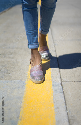 Girl walking on a yellow caution line. Espadillas with a marine style