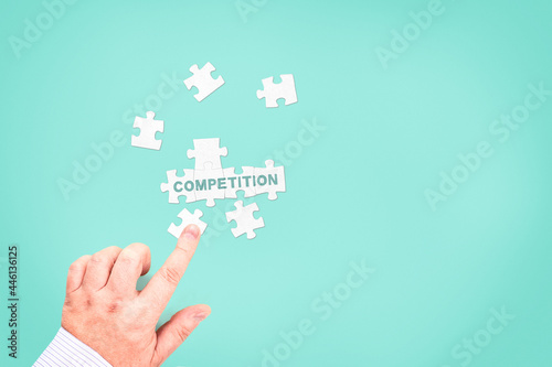 A businessman collects the word "Competition" from puzzle pieces