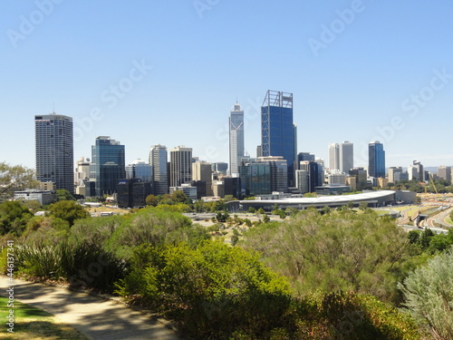 Skyline of a metropolitan area against a clear blue sky. Skyscrapers and office buildings. Park with green vegetation in the foreground. View of Perth from Kings Park, Western Australia. © Emerson