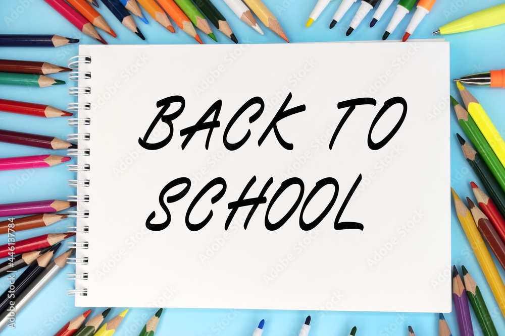 Back to school is written on a notebook that lies on a blue background ...