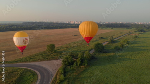 High altitude aerial drone wide view. A collection of hot air balloons are flying through a clear blue sky on a morning in Ryazan  Russia 18 july 2021