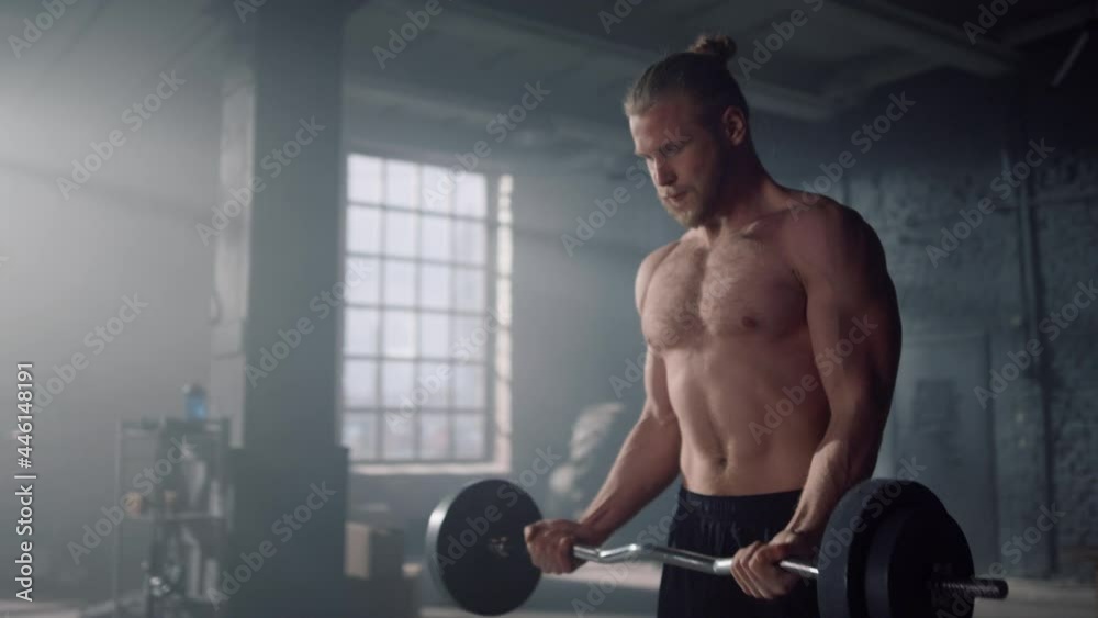 Man doing exercises on biceps muscles in gym. Man screaming during training 