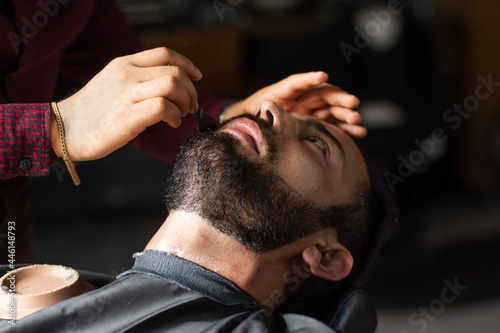 Mid age customer having a shave in a barbershop