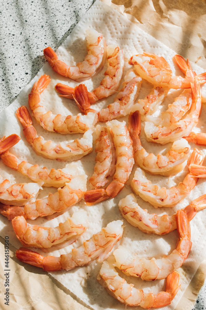 raw de-shelled prawns shrimp with tails on paper towel in the sun raw de-shelled prawns shrimp with tails on paper towel in the sun