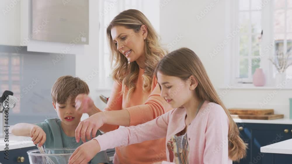 Mother With Two Children In Kitchen At Home Having Fun Baking Cakes Together Mother With Two Children In Kitchen At Home Having Fun Baking Cakes Together
