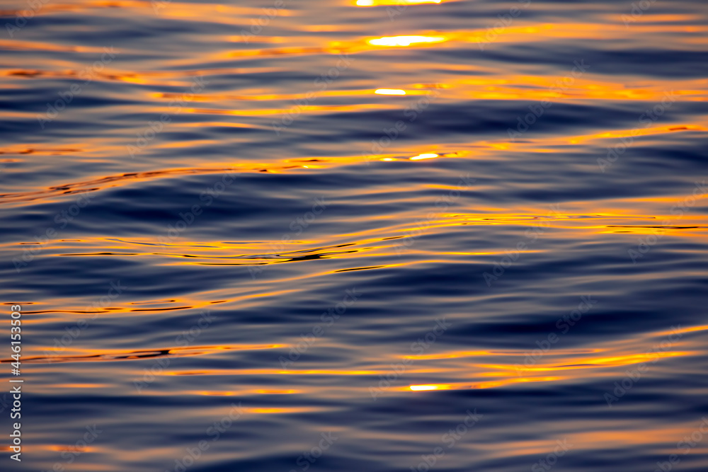 Reflection of the setting sun in a wave of water. Natural background texture Reflection of the setting sun in a wave of water. Natural background texture