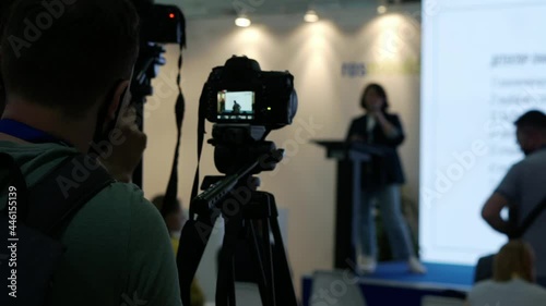 A videographer is filming the speakers in the conference room.