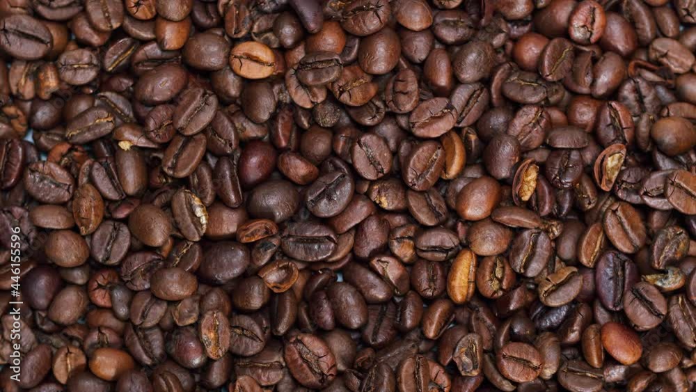 Close-up of rotating coffee beans on table. Shooting of coffee in studio. Macro footage of the bean. Cooking healthy food and drink video. Close-up of rotating coffee beans on table. Shooting of coffee in studio. Macro footage of the bean. Cooking healthy food and drink video.