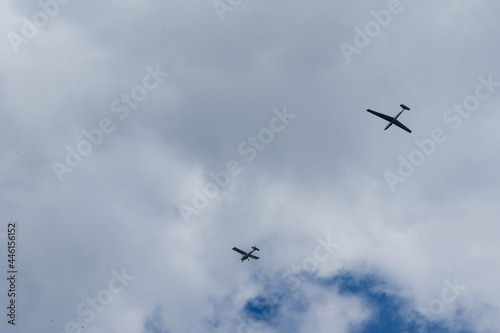 Glider planes flying in the sky. Extreme active sport. Cloudy blue sky with small motorless aircrafts.