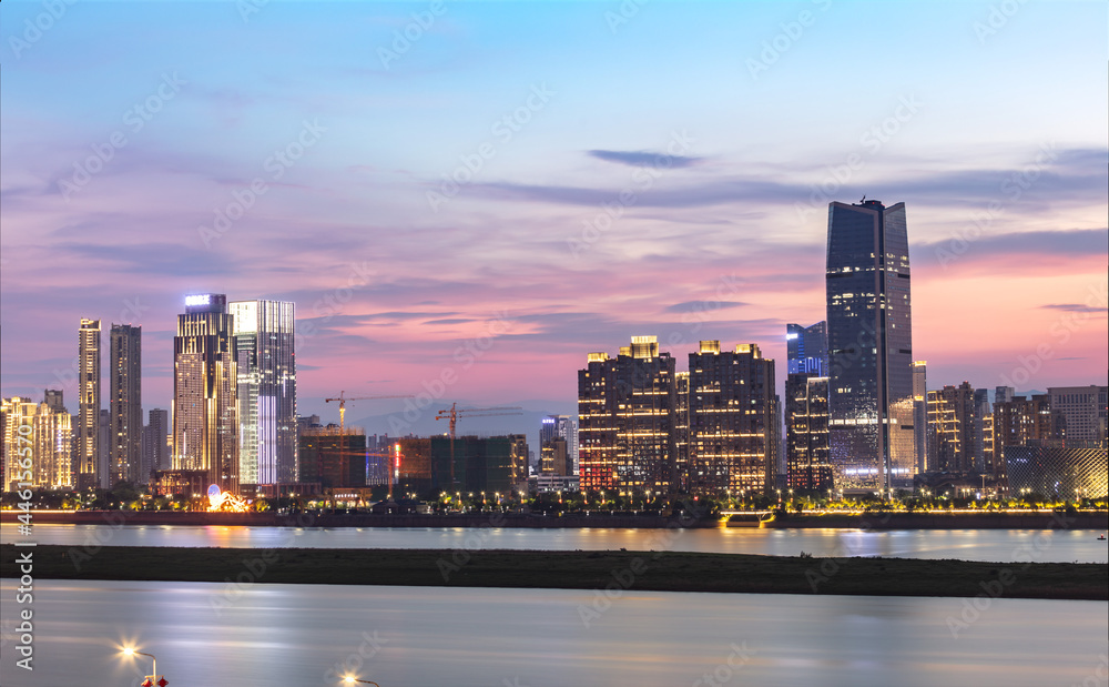 Obraz premium Located along the Ganjiang River, Honggutan New District is a modern city with bright lights and beautiful scenery at night. A capital city in eastern China.