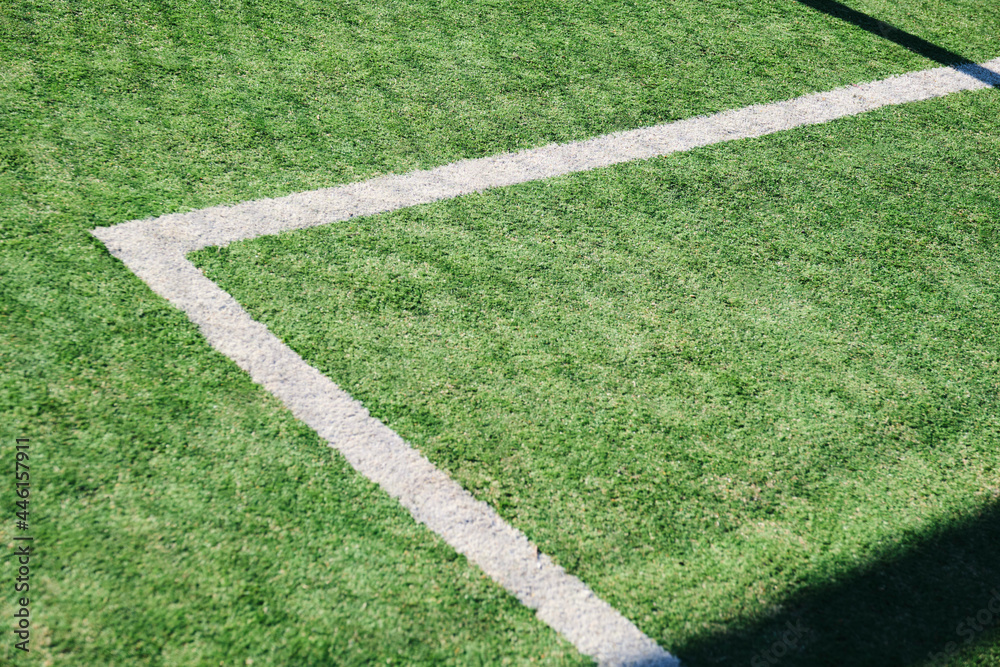 Naklejka premium Synthetic soccer field, green with white lines, located outdoors.